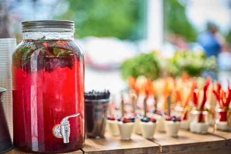Tasty appetizers served in glass jars on wooden table.