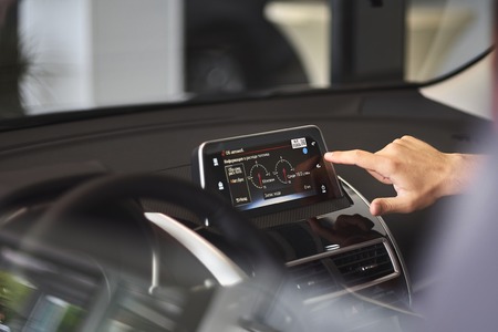 Modern media display in the interior of the car. The screen with multimedia shows fuel consumption....