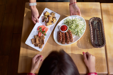 waiter serves a delicious salad with meat in a restaurant, Top viewの写真素材
