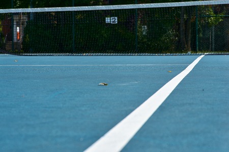 Tennis courts with blue surface and mesh fences. tennis court in a public parkの写真素材