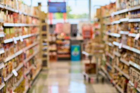 Blurry background texture of aisle between shelves filled with goods in supermarket environment. concept of trade, the purchase of foodの写真素材