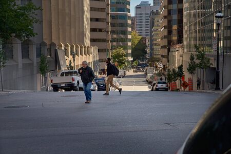 Montreal, Quebec, Canada, September 14, 2018: Pedestrians are crossing a pedestrian crossing, to a green traffic light. People from the back girl on the shoulders of dad. security concept on the streetのeditorial素材