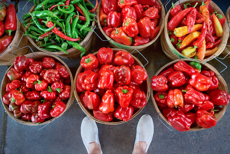 Colourful peppers, red, yellow and green, are sold in a wooden barrel at outdoor market place, Their name are bell pepper, sweet pepper or capsicum. Top viewの写真素材