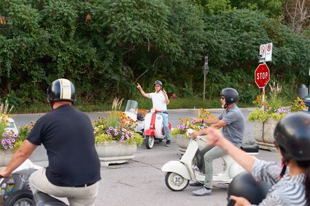 Montreal, Quebec, Canada September 01, 2018: tourists on scooters, a joint excursion to Belvedere Camillien-Houde. Tourists scooters choose the direction of the trip. Lifestyle and travel concept.のeditorial素材