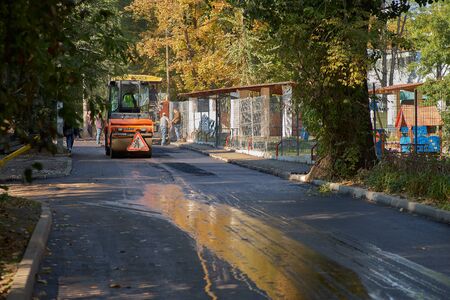 Chisinau, Moldova, March 25, 2019: Team pave the roadway. Worker operating the process of building...