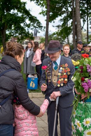 Chisinau, Moldova, May 9, 2019: war veteran receives congratulations on Victory Day. Children with parents give flowers celebrates the 74nd anniversary of the Victory.のeditorial素材