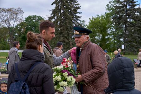 Chisinau, Moldova, May 9, 2019: war veteran receives congratulations on Victory Day. Children with parents give flowers celebrates the 74nd anniversary of the Victory.のeditorial素材