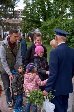 Chisinau, Moldova, May 9, 2019: war veteran receives congratulations on Victory Day. Children with parents give flowers celebrates the 74nd anniversary of the Victory.のeditorial素材