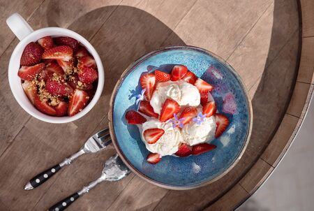 Morning breakfast in a blue plate on the table. vanilla Ice cream with caramel and fresh strawberries. selective focus.の写真素材