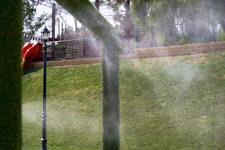 Outdoor air conditioning climate in hot weather. Street gate climate control in the waterpark. Aerosol spraying water jets, spraying cooling water. Air conditioning nozzle.の写真素材