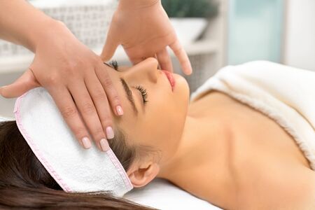 spa, resort, beauty and health concept - beautiful woman in spa salon getting face treatment, close upの写真素材