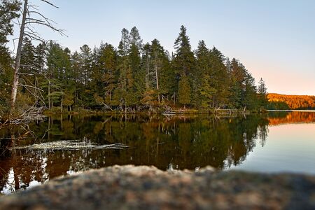 Calm lake reflection in sunrise. Copy Space. in Quebec, Harrington. Travel to Canada.