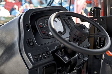 Steering wheel and the controls in the cabin of the new tractor, view inside Industrial Vehicle.