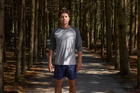 Portrait of Sport and fitness runner man resting in forest after marathon run and high intensity...