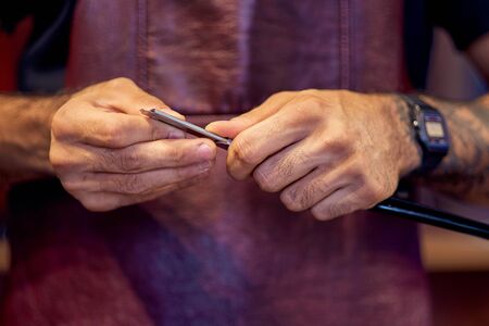 Cropped image of barber in stylish classic wear holding a straight razor.の写真素材