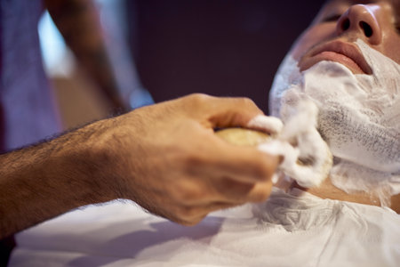 Shaving process of beards in Barbershop. Master makes the client shave his beard with vintage straight razor. Work in the Barber shop, The process of the hairdresser.の写真素材