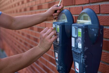 Close Up Of Man Putting Money In Parking Meter.