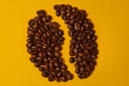 coffee beans on a yellow background, concert coffee symbol