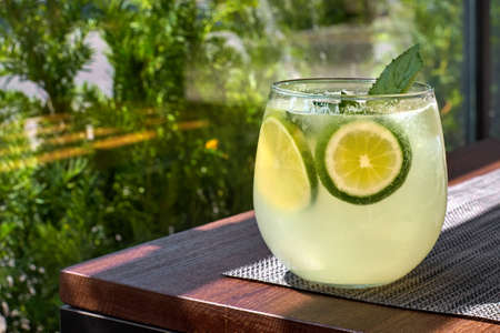 Lemonade or mojito cocktail with lemon and mint, cold refreshing drink or beverage with ice
