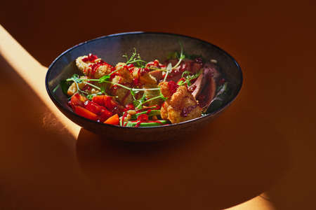 fresh summer salad with grilled beef and avocado, shrimps and banana breadcrumbs on an orange...