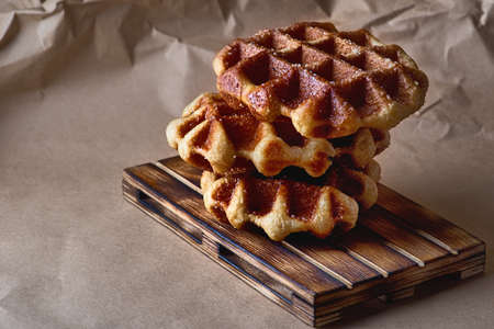 Belgian waffles on brown paper and wooden trayの写真素材