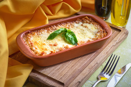 Traditional italian lasagna with vegetables, minced meat and cheese. On a wooden background. Concept of healthy eating for menu.の写真素材