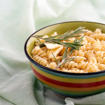 Boiled fusilli pasta with rosemary in a plate a on bright table. close up, the still life, selective focus.の写真素材