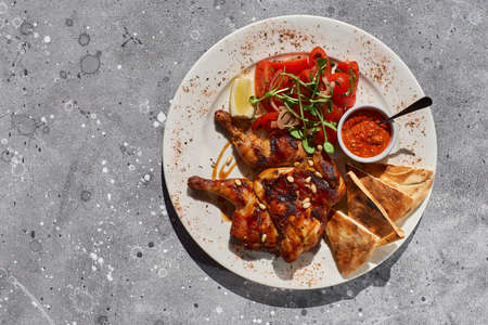 Roast whole turkey or chicken in plate with grilled vegetables on stone background. Flat lay, Top...