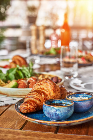 traditional breakfast with croissants and coffee served on wooden table, time for breakfast or lunch, waiting for guests. french breakfast.の写真素材