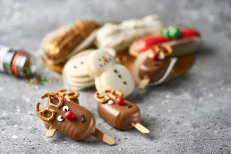 Banner for Christmas and New Years. sweet deer, eclairs, snowflakes, sweet snowman on a concrete background.の写真素材