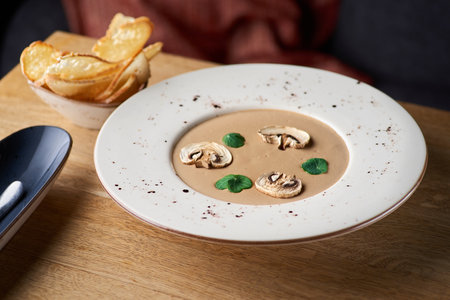 Vegetarian food. Mushroom soup puree with cream, porcini, champignons on the table, serving in a restaurant, menu food concept.の写真素材