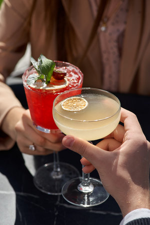 couple drinking cocktails. Concept of relationship.Close-up on hands with drinks