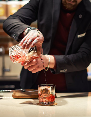 Bartender prepairing a cocktail at the bar, selective focus, food and drink concept.