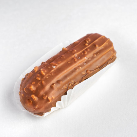 Traditional French dessert. eclair with custard and milk chocolate glaze on a white background....