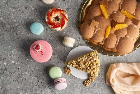 Selection of various pieces of cake - Choux pastries, macarons, chocolate velvet cake on a gray...