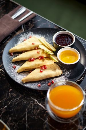 russian pancakes in plate, bowl with strawberry jam, tea on table. Health concept