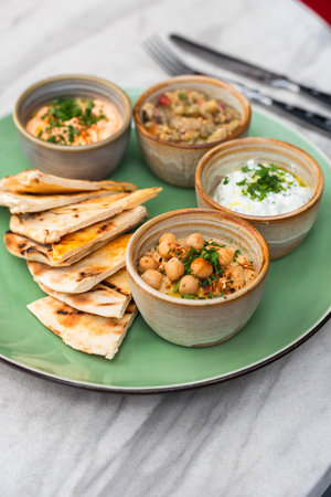 Snacks: hummus with sauce, eggplant caviar, Tzadziki- healthy and tasty food. Close-up plate with...