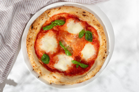 Margarita or margherita pizza with heart shaped mozzarella cheese on white background, top view, menuの写真素材