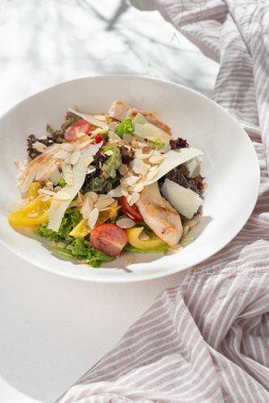 Classic caesar salad with grilled chicken fillet and parmesan cheese on white background for restaurant menu.の写真素材