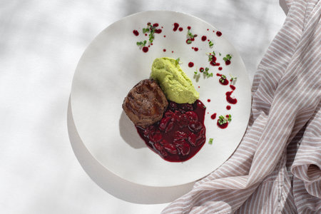 Restaurant Food - Filet mignon with edamame puree and cherry demiglace sauce on a white plate. Copy space,Selective focus. Healthy concept, menu. flat layの写真素材