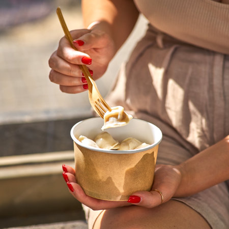 boiled ravioli with parsley, Traditional pelmeni, ravioli, dumplings filled with meat in takeaway box in female hands, mockupの写真素材
