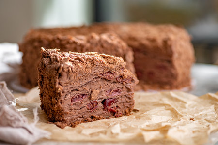 Napoleon cake with custard is decorated with cherries and grated chocolate on table. Dessert...