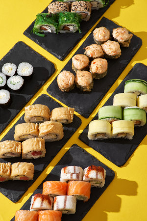 set of sushi roll different type on a yellow background. Top view. Traditional Asian foodの写真素材