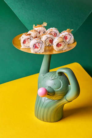 Sushi roll with tuna, shrimp, salmon, smoked eel, avocado, philadelphia cheese on a yellow background.の写真素材