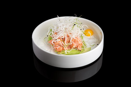 Restaurant dish - shrimp tartare with avocado, cream cheese, sweet chilli sauce on white plateの写真素材