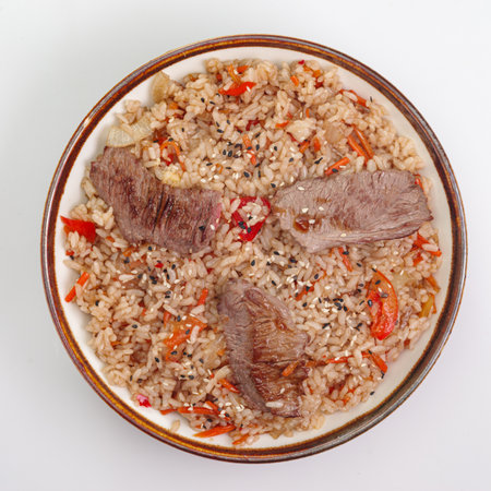 Fried rice with beef and vegetables isolated on white background. Traditional chinese food - fried rice with egg and beef in ceramic bowl. Bowl with fried rice beefの写真素材