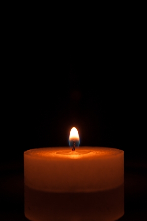 Burning candle on a black backgroundの写真素材