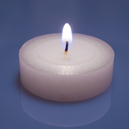 Burning candle on a blue backgroundの写真素材