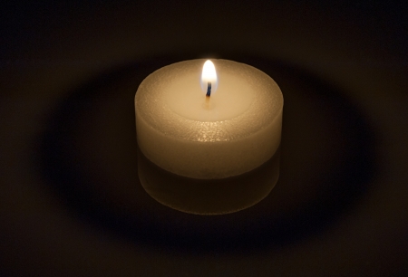 Burning candle on a black backgroundの写真素材