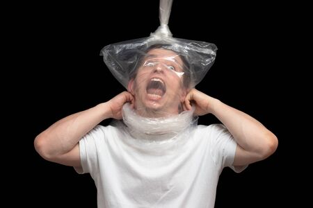 Consuming plastic bags is killing. The consumer is strangled by plastic bags. A man suffocates in his trash. The hanged man will die. Save the environment from pollution - save humanityの写真素材